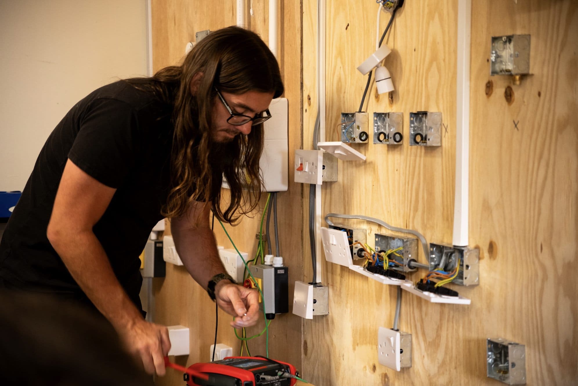 Student practising wiring in a training bay